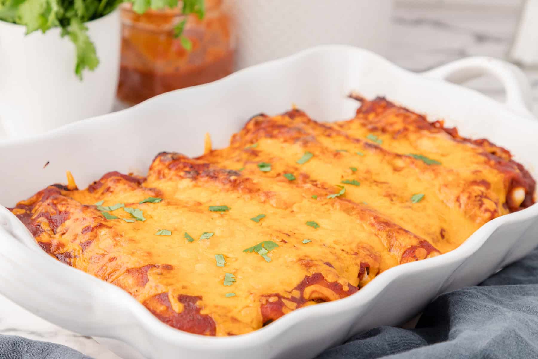 BBQ chicken enchiladas in a white baking dish