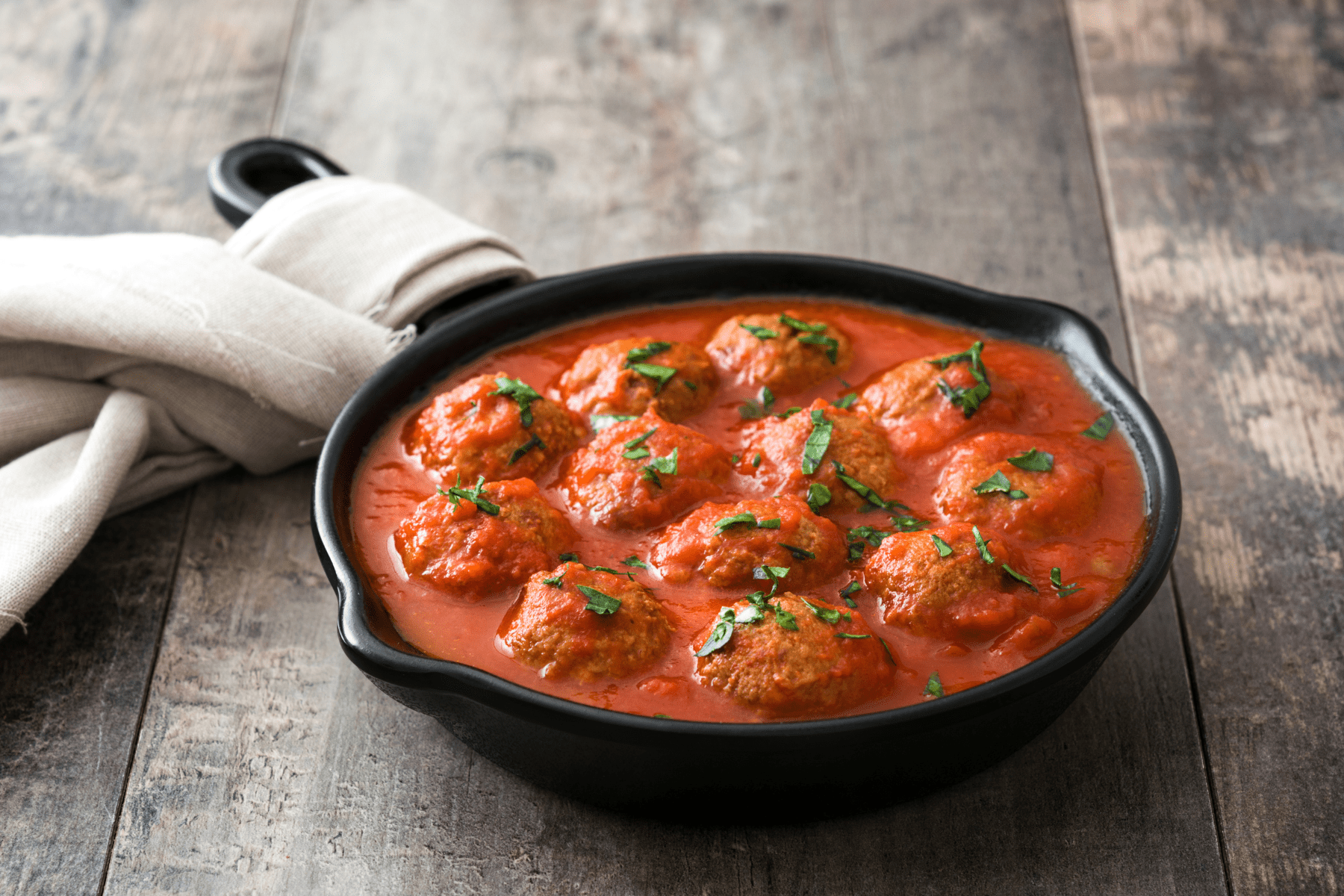 meatballs in spaghetti sauce in a cast iron skillet