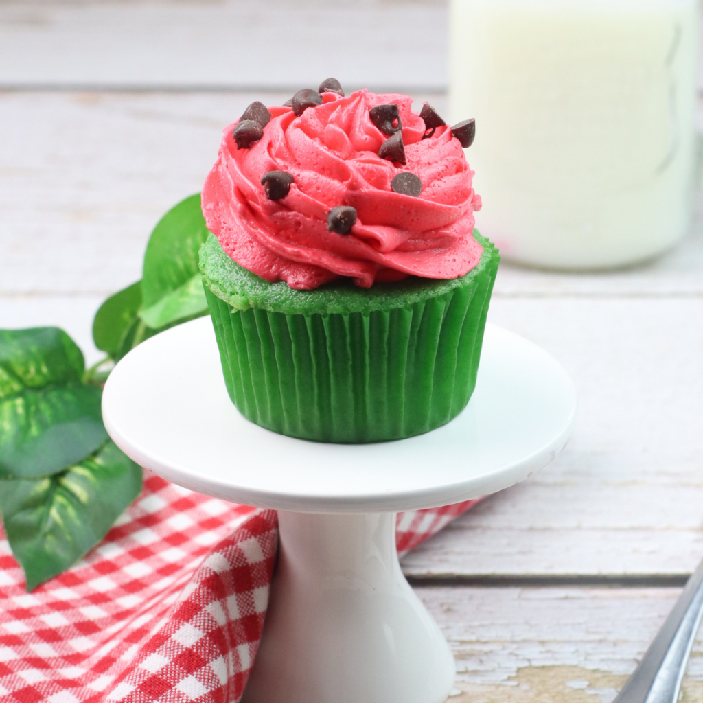 watermelon cupcake with watermelon frosting on a white cake plate