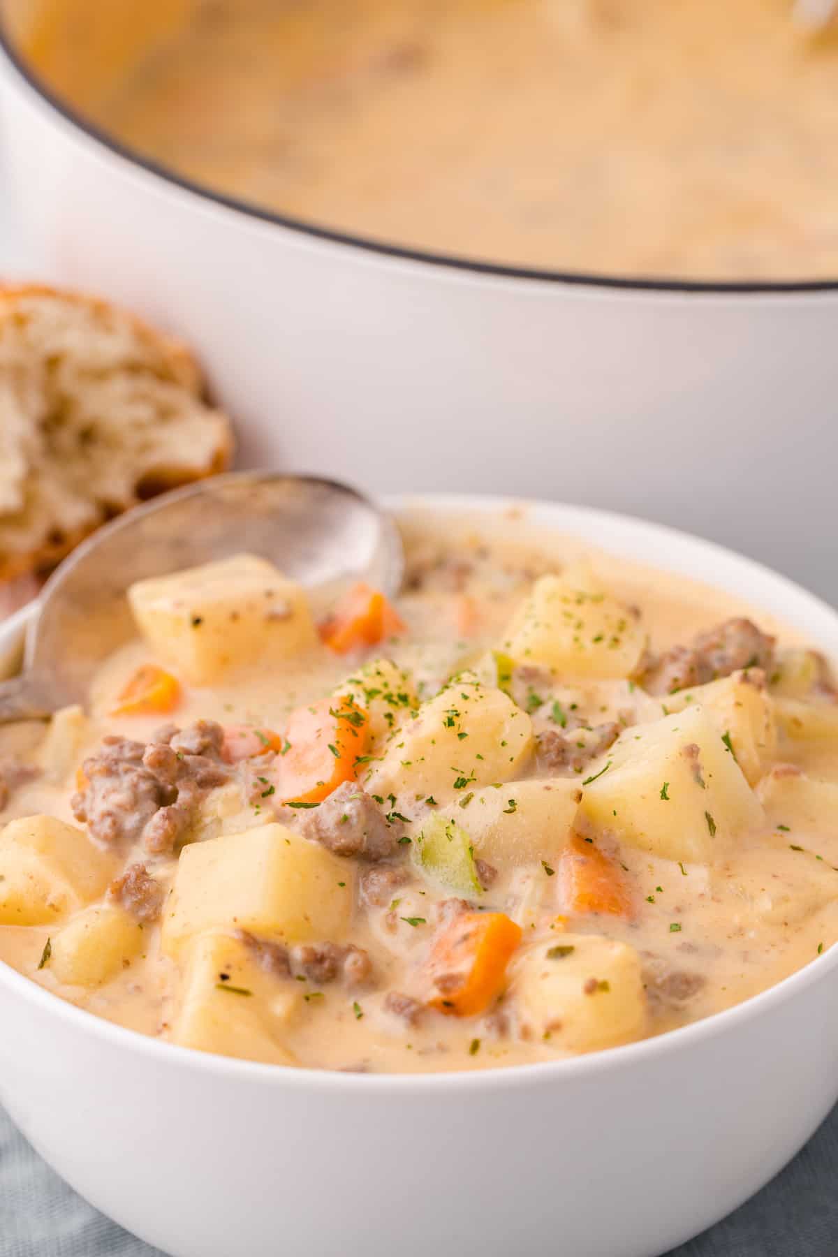 the best cheeseburger soup from Taste of Home in a white bowl with a spoon