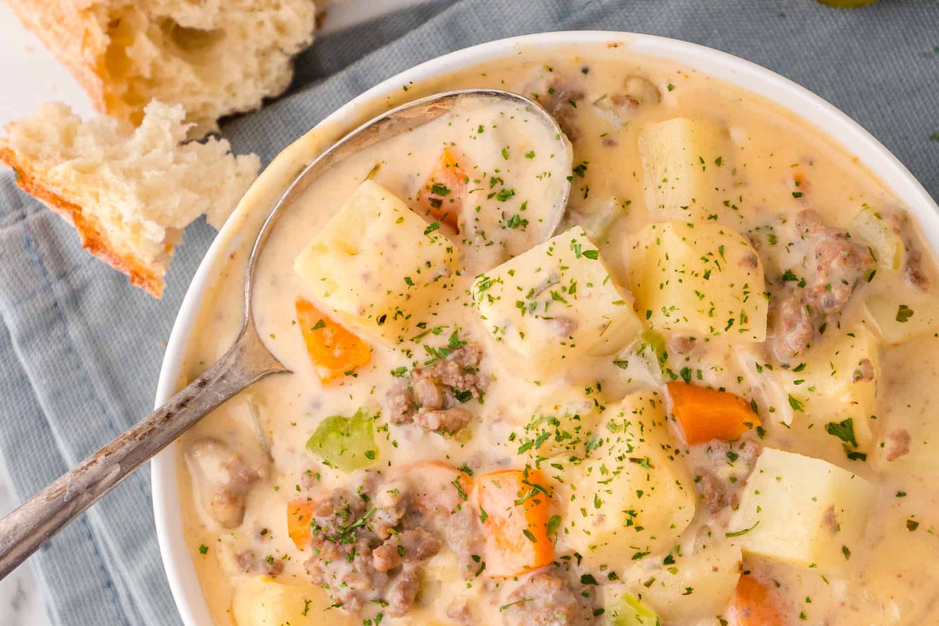 a white bowl full of cheeseburger soup