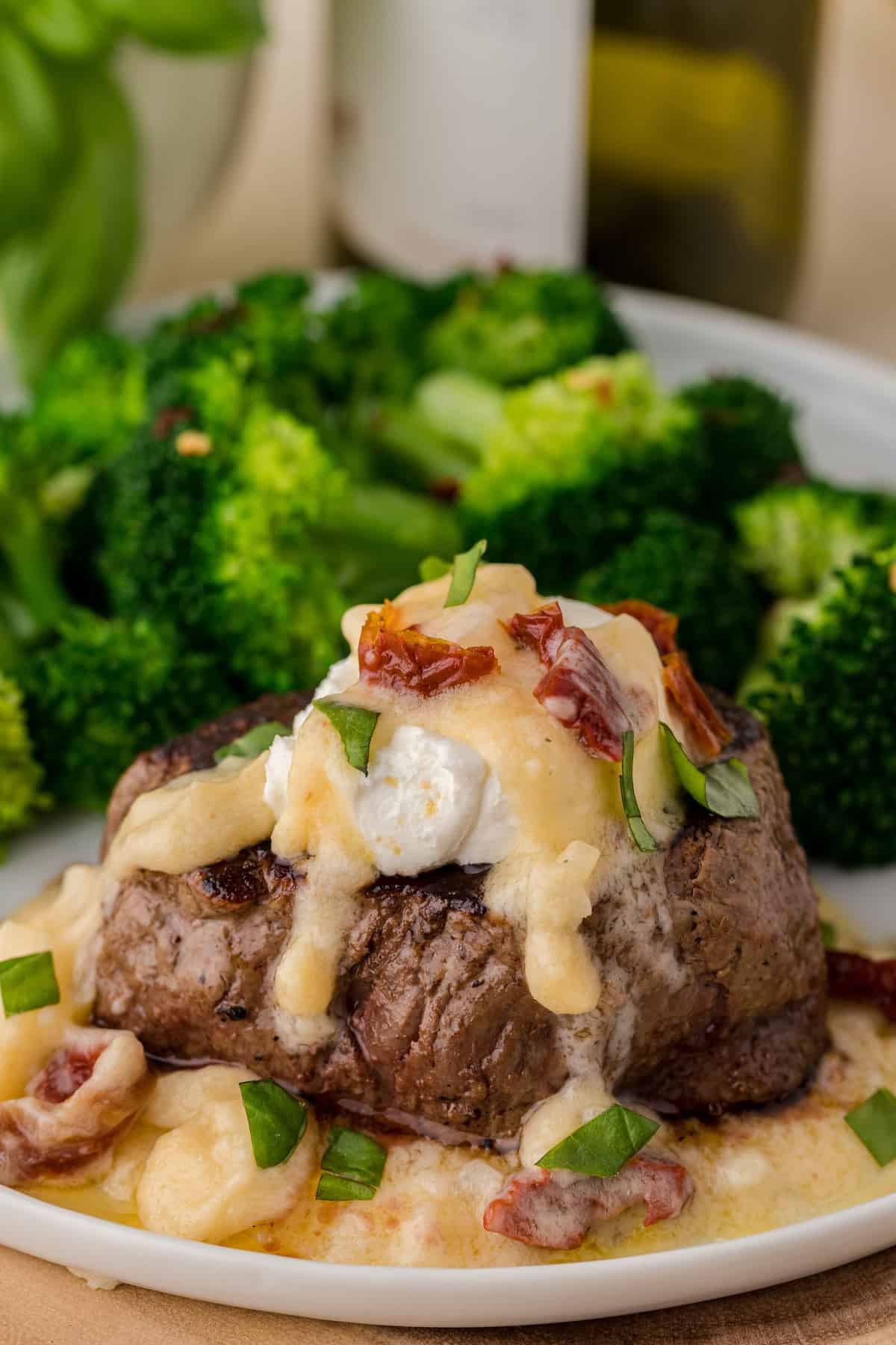 a filet mignon with goat cheese and lemon butter sauce with sun-dried tomatoes and fresh basil