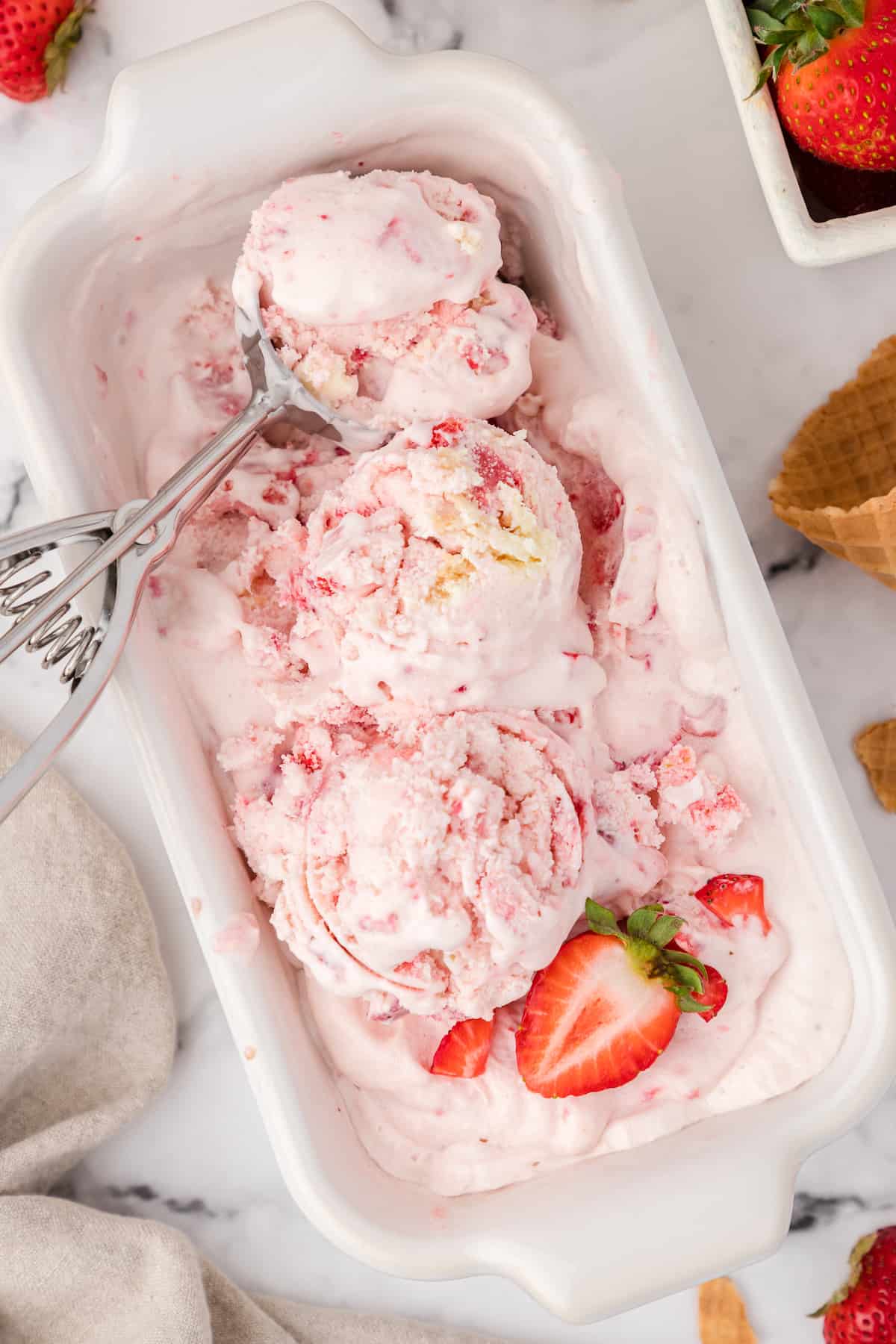 three scoop of strawberry cheesecake ice cream in a loaf pan