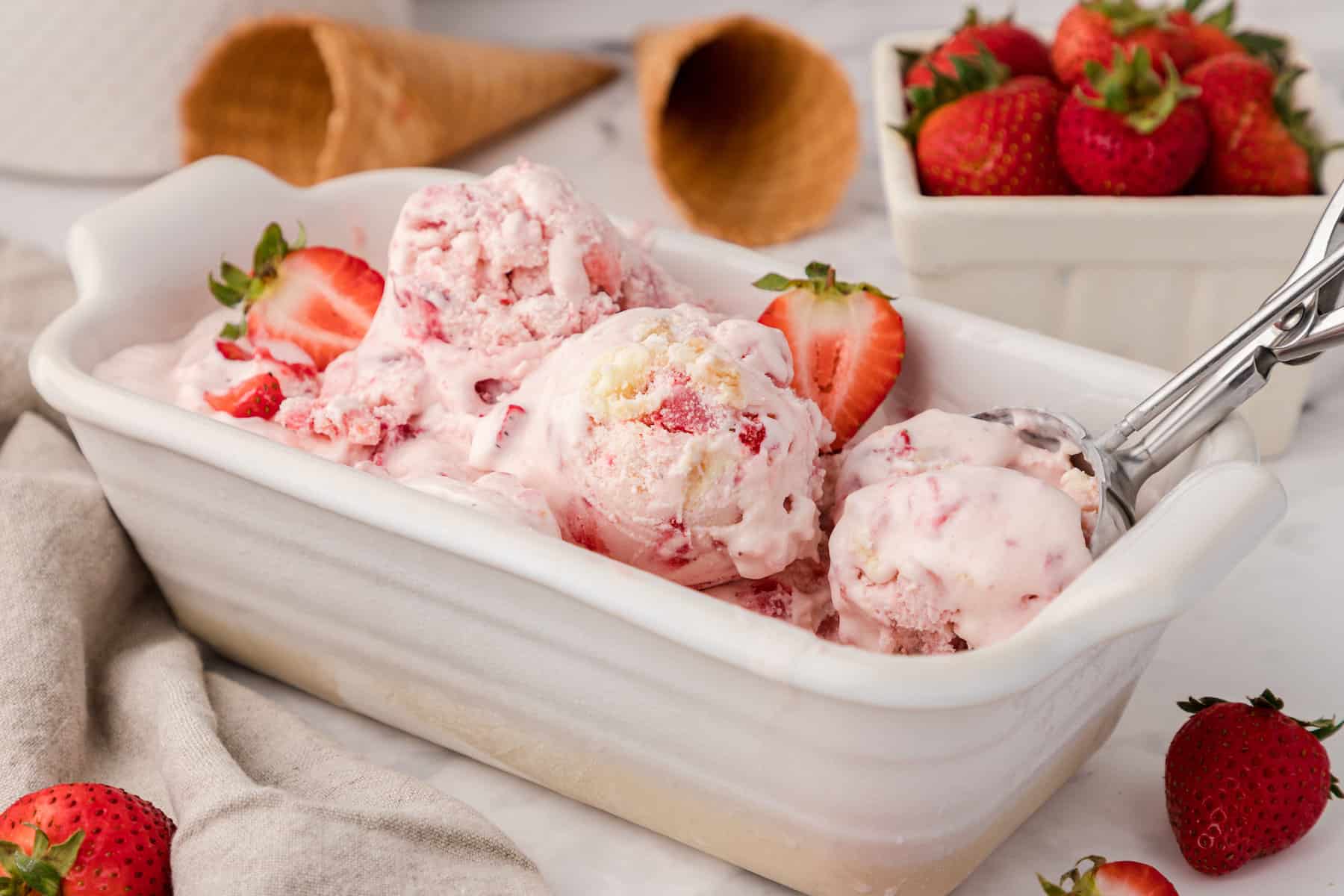 three scoops of strawberry cheesecake ice cream in a loaf pan