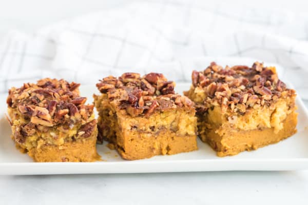 three slices of pumpkin dump cake on a white tray