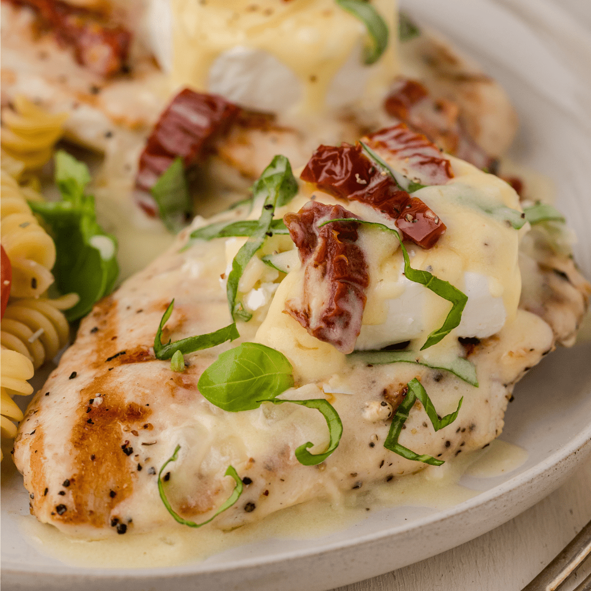 a close up of Carrabba's chicken bryan copycat recipe with sun-dried tomatoes, goat cheese, basil, and lemon butter sauce