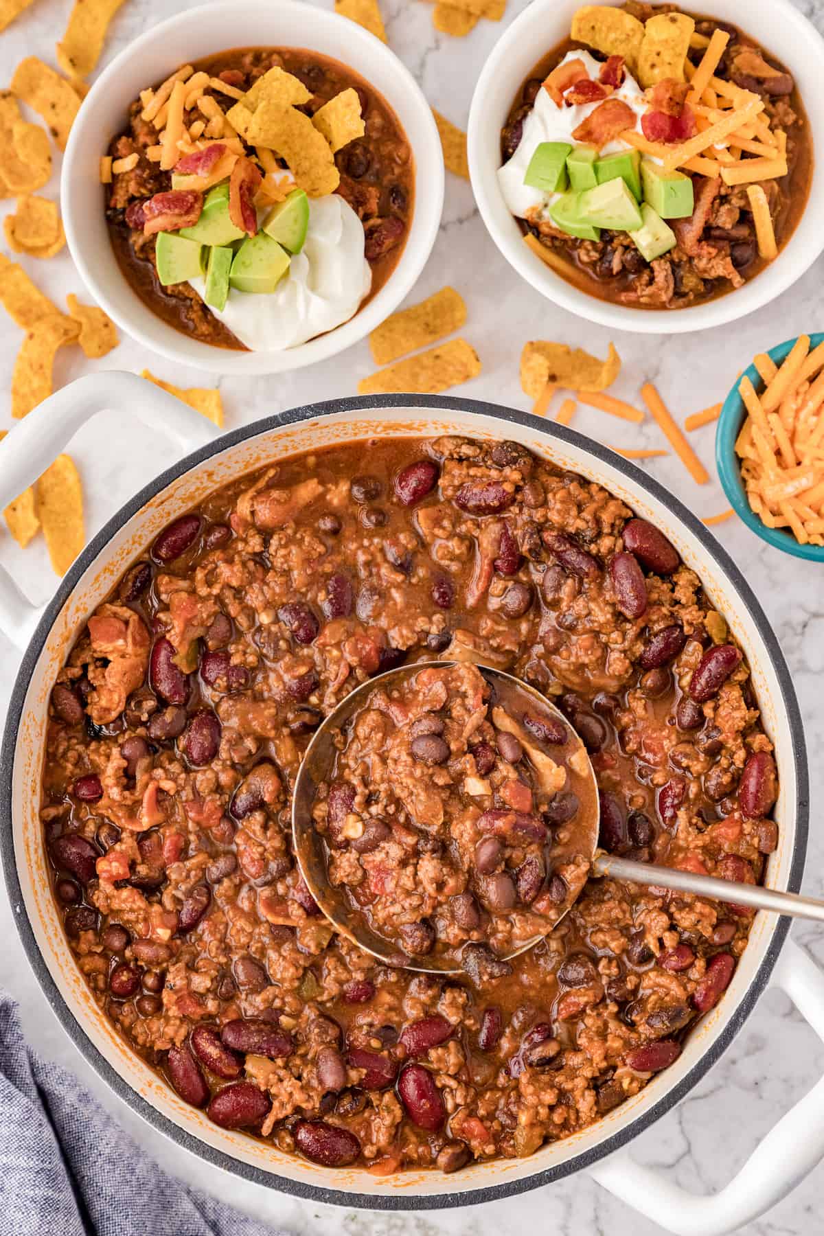 a big pot of bacon chili with two servings in small white bowls