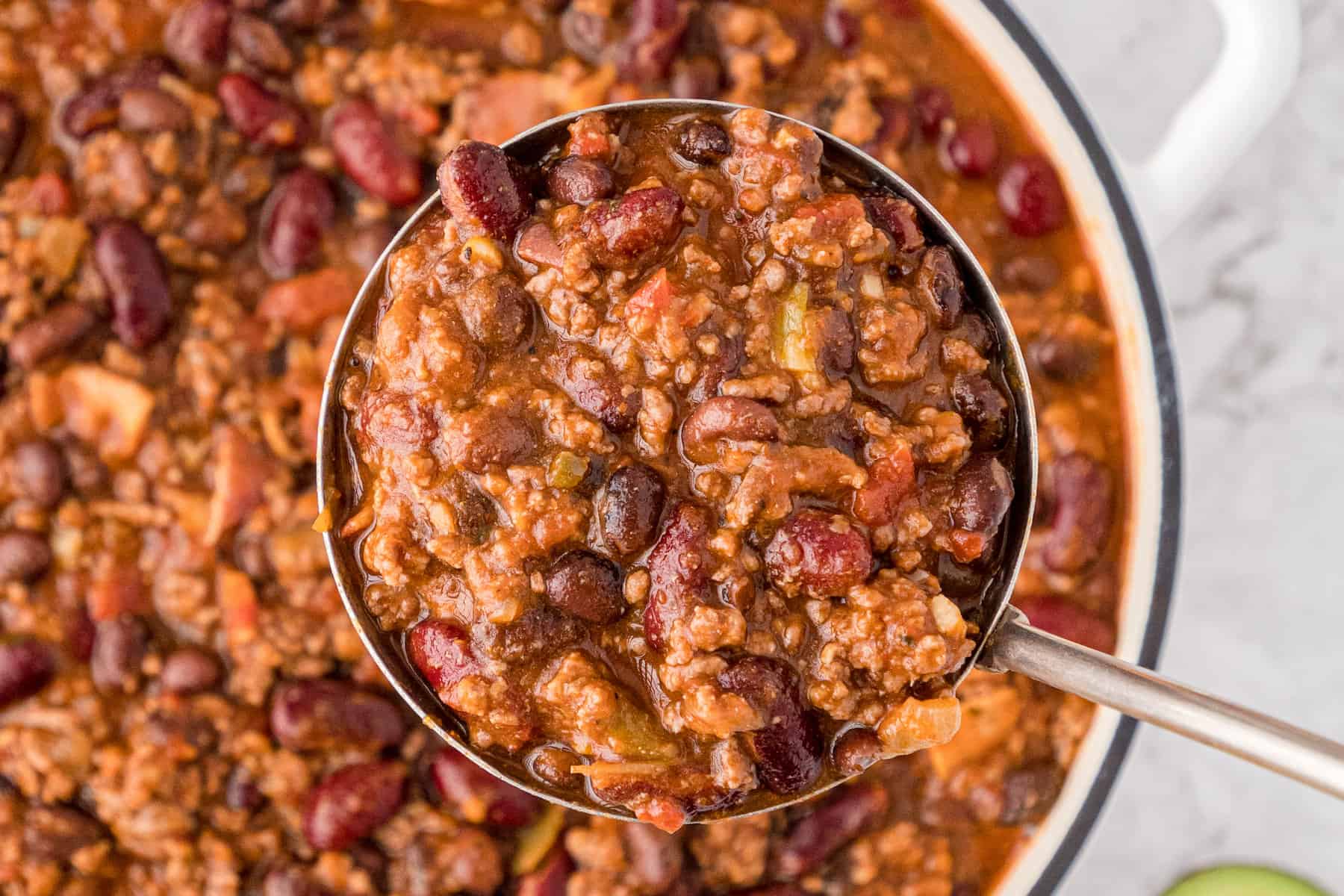 a close up of bacon chili in a ladle
