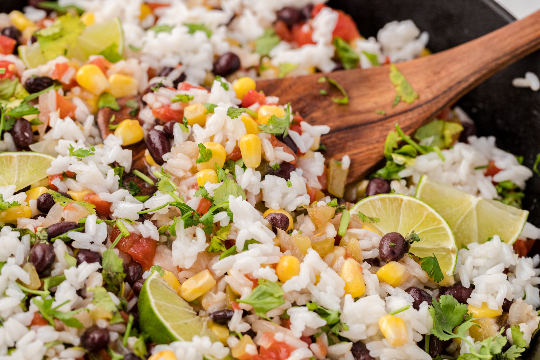 a close up of cilantro lime rice with black beans, tomatoes, and corn