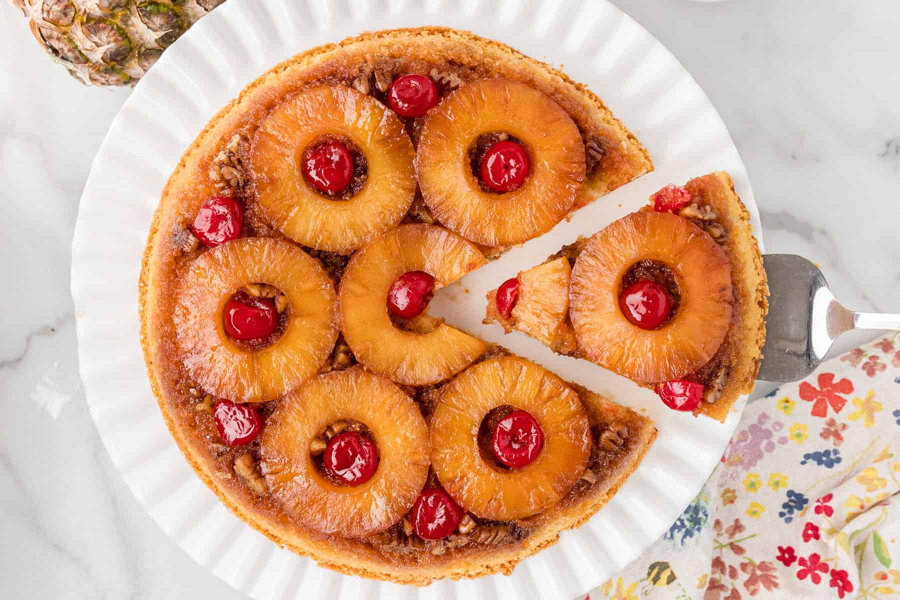 one slice being removed from a skillet pineapple upside down cake