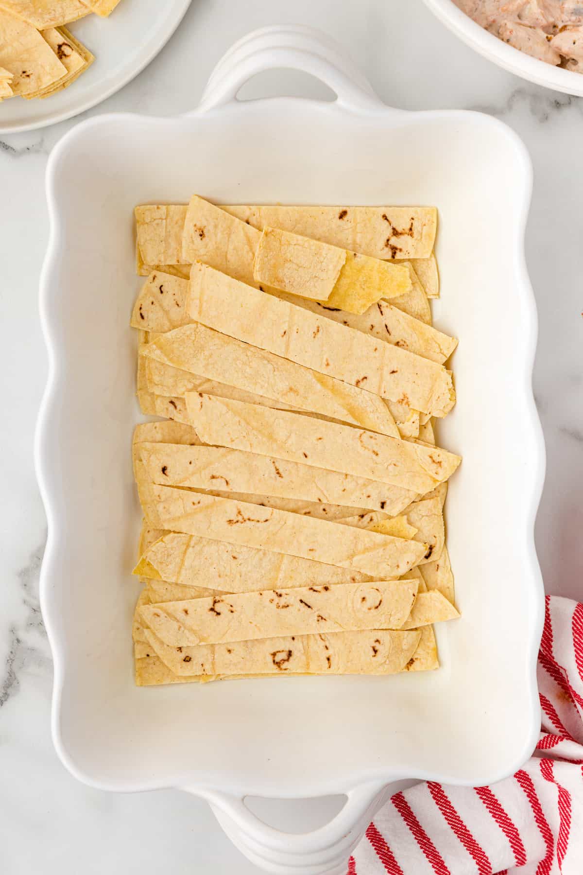 layer the tortilla strips in the bottom of the casserole dish