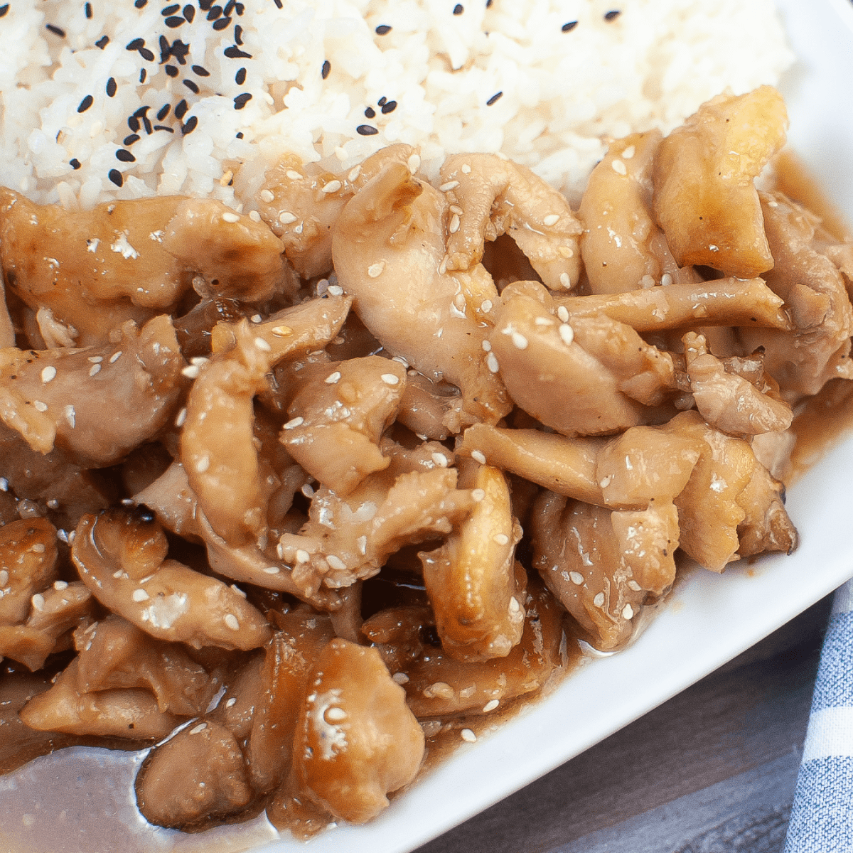 air fryer teriyaki chicken thighs with rice and sesame seeds on a white plate