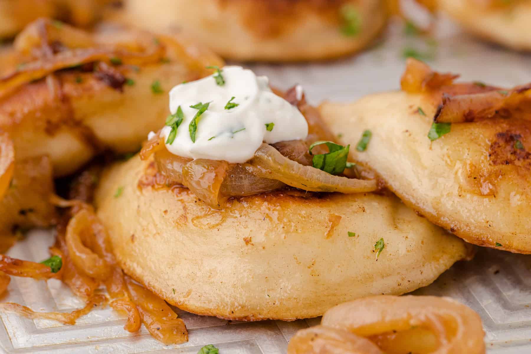 one pierogy with butter, onions, and sour cream