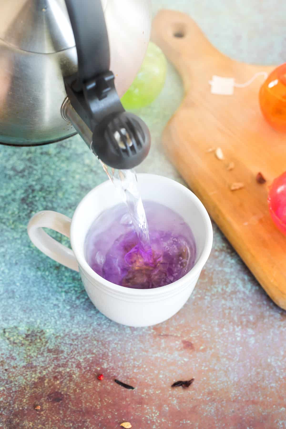 pouring boiling water over top of a hot tea bomb in a tea cup