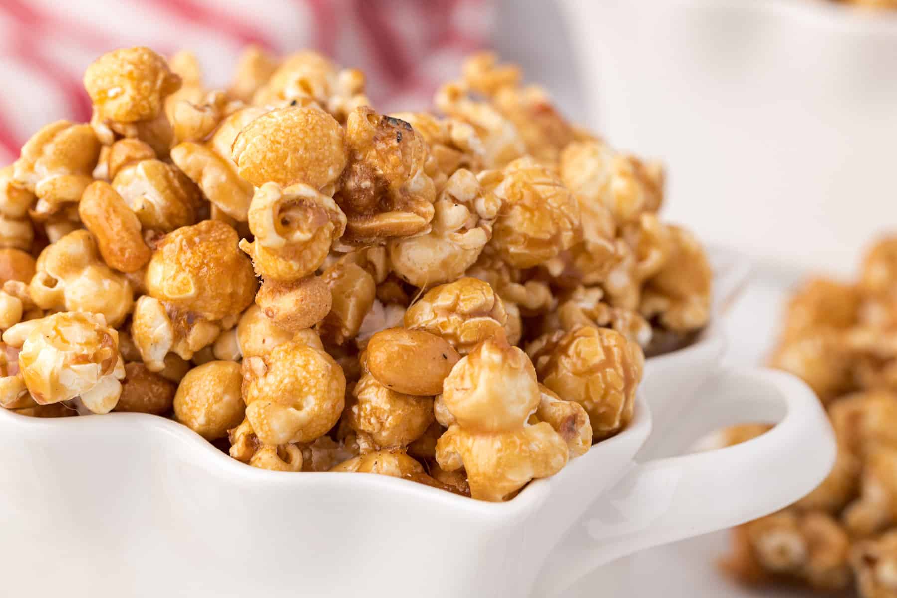 a close up of homemade Cracker Jacks in a small white bowl