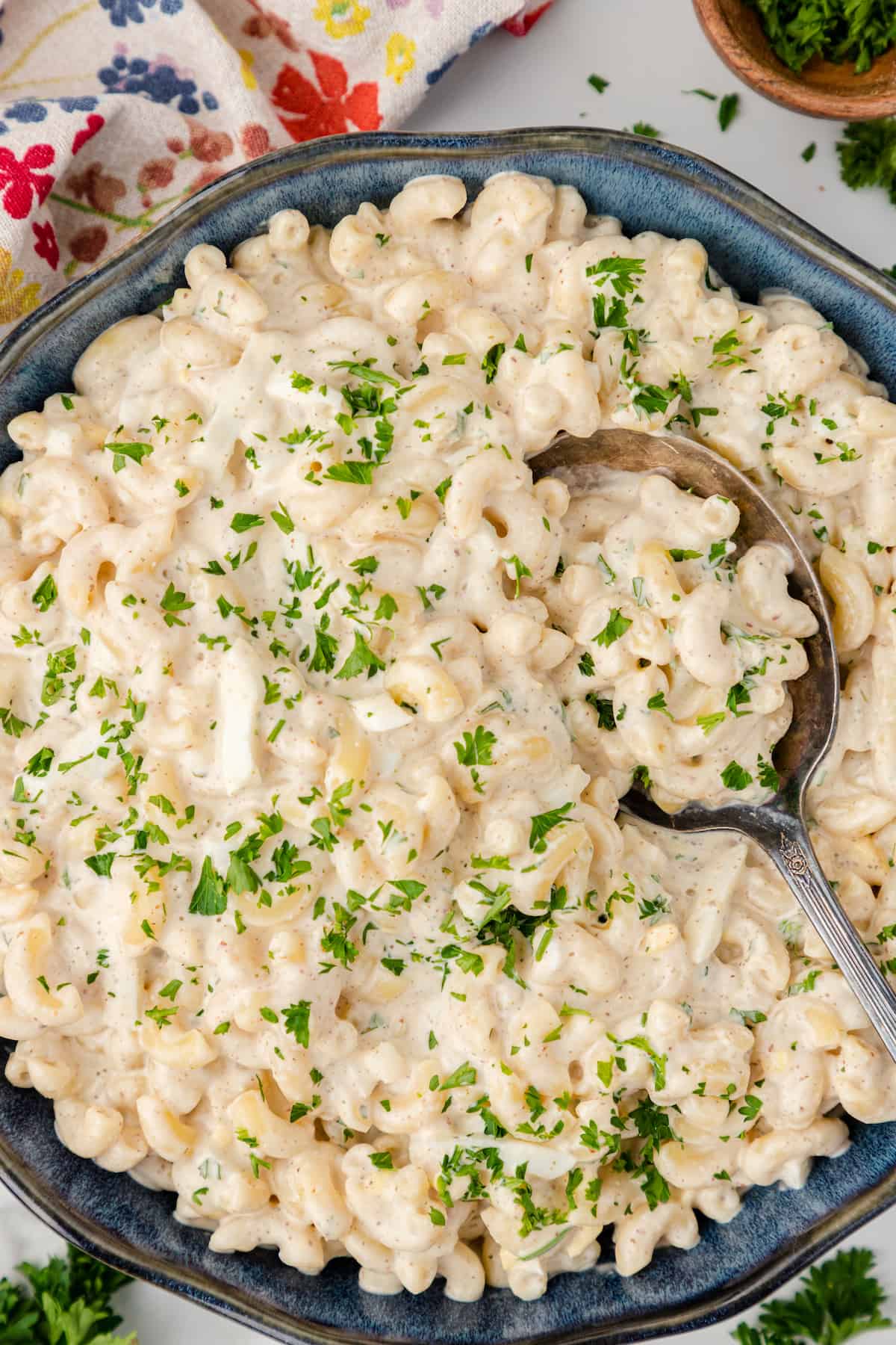 a big blue bowl full of creamy macaroni salad