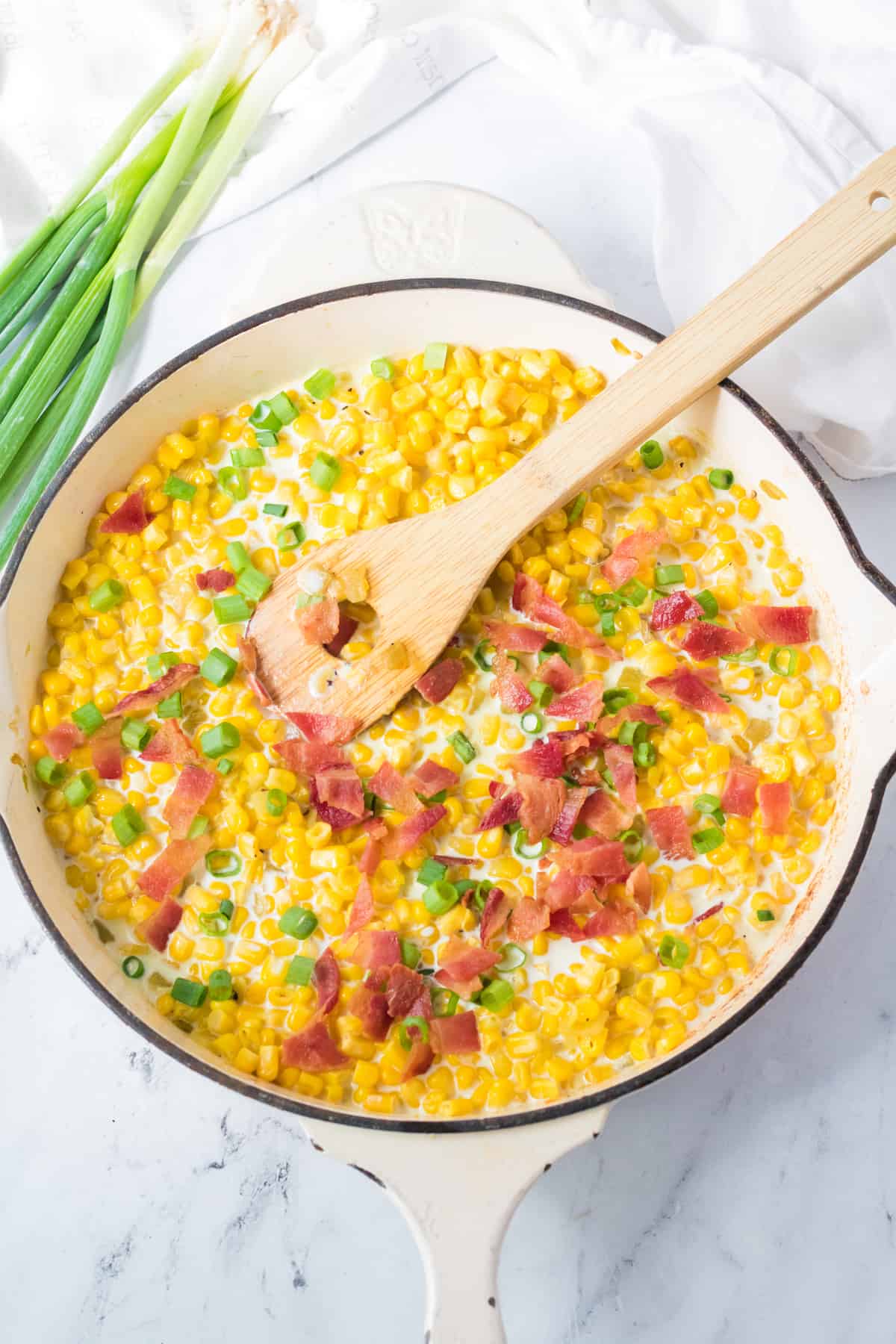 add the bacon and heavy cream to the corn