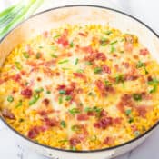 cheesy skillet corn with bacon and green onions in a skillet