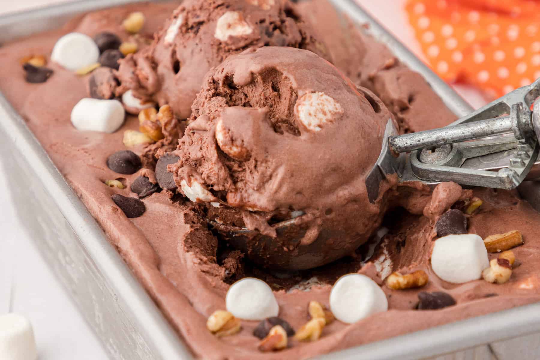 a close up of one scoop of homemade rocky road ice cream in a loaf pan