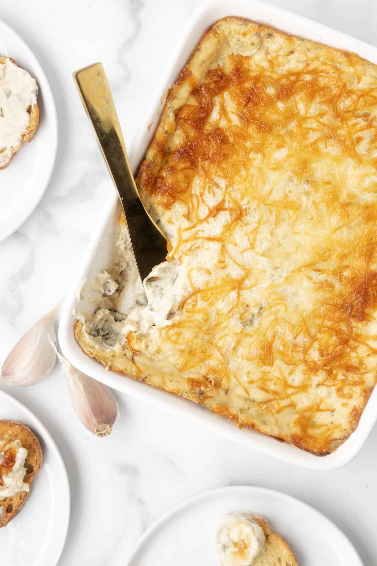 a baking dish with garlic bread dip with cream cheese