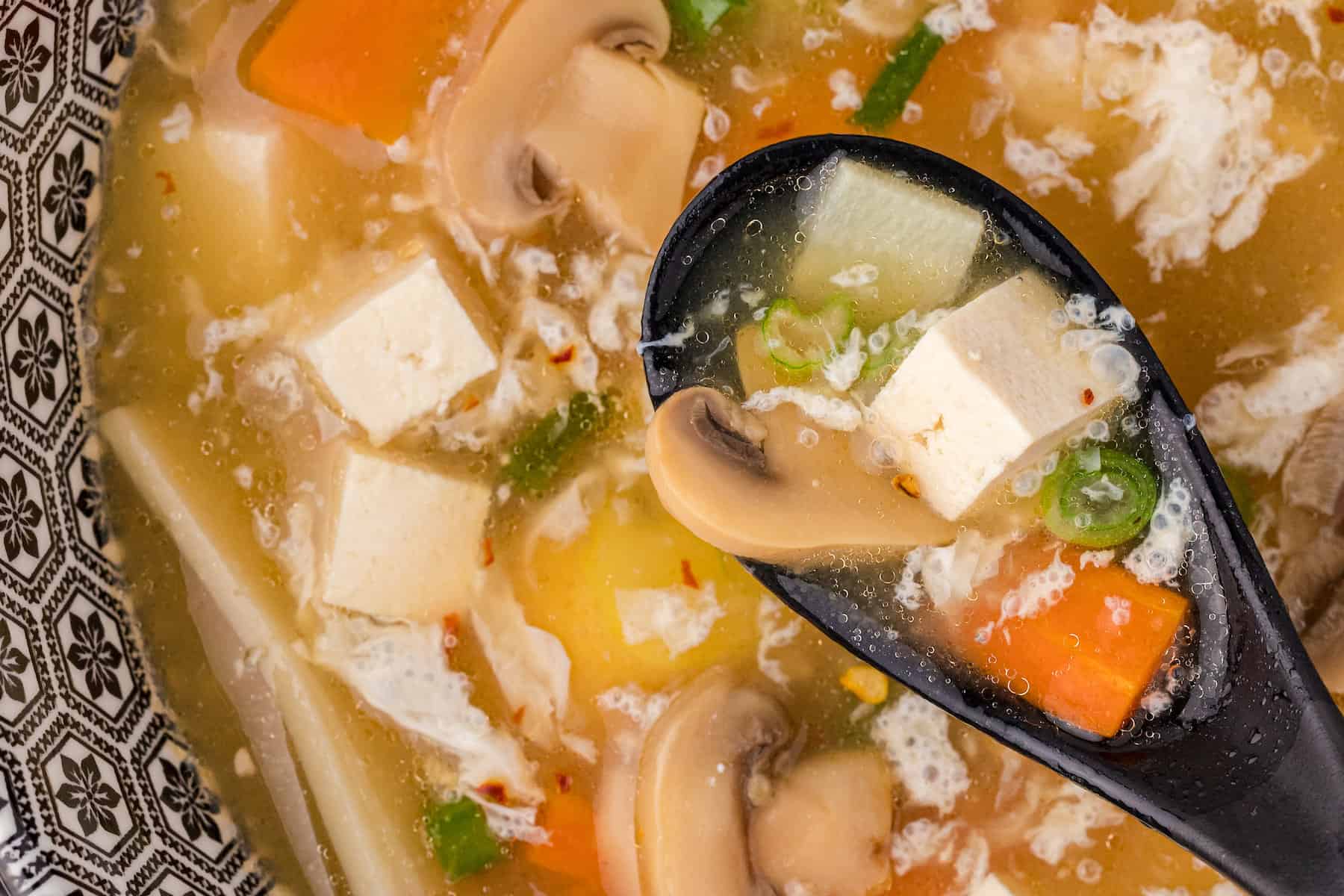 hot and sour soup in a blue and white bowl