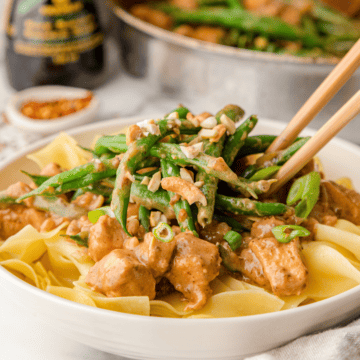 Indonesian peanut butter chicken stir fry with green beans over noodles with chopsticks