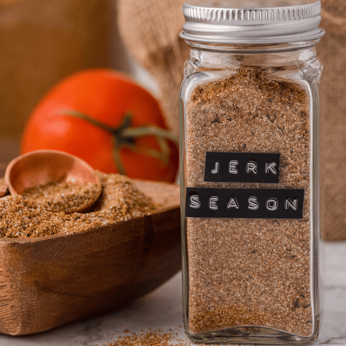 a bottle of Jamaican Jerk Seasoning Mix next to a bowl of the seasoning