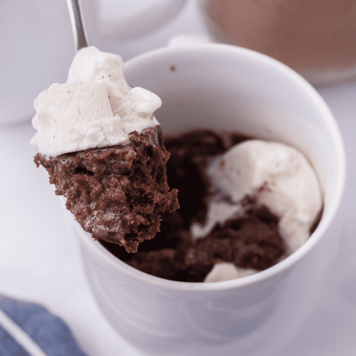 a microwave brownie in a mug topped with ice cream