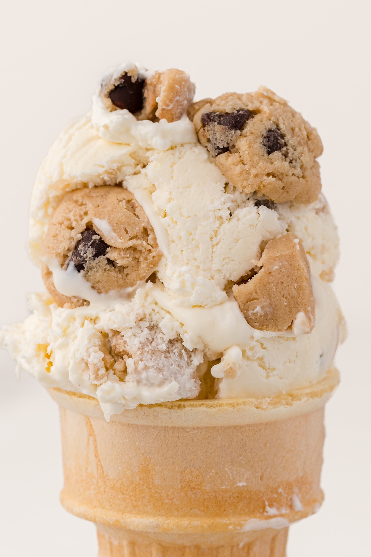 a close up of an ice cream cone with cookie dough ice cream