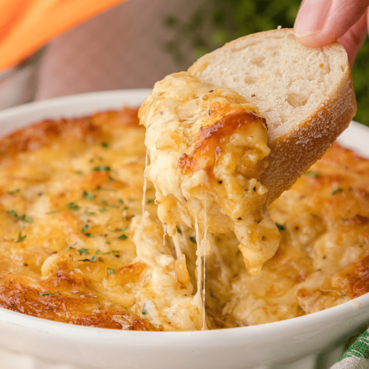 a crostini with gooey hot onion dip with swiss cheese