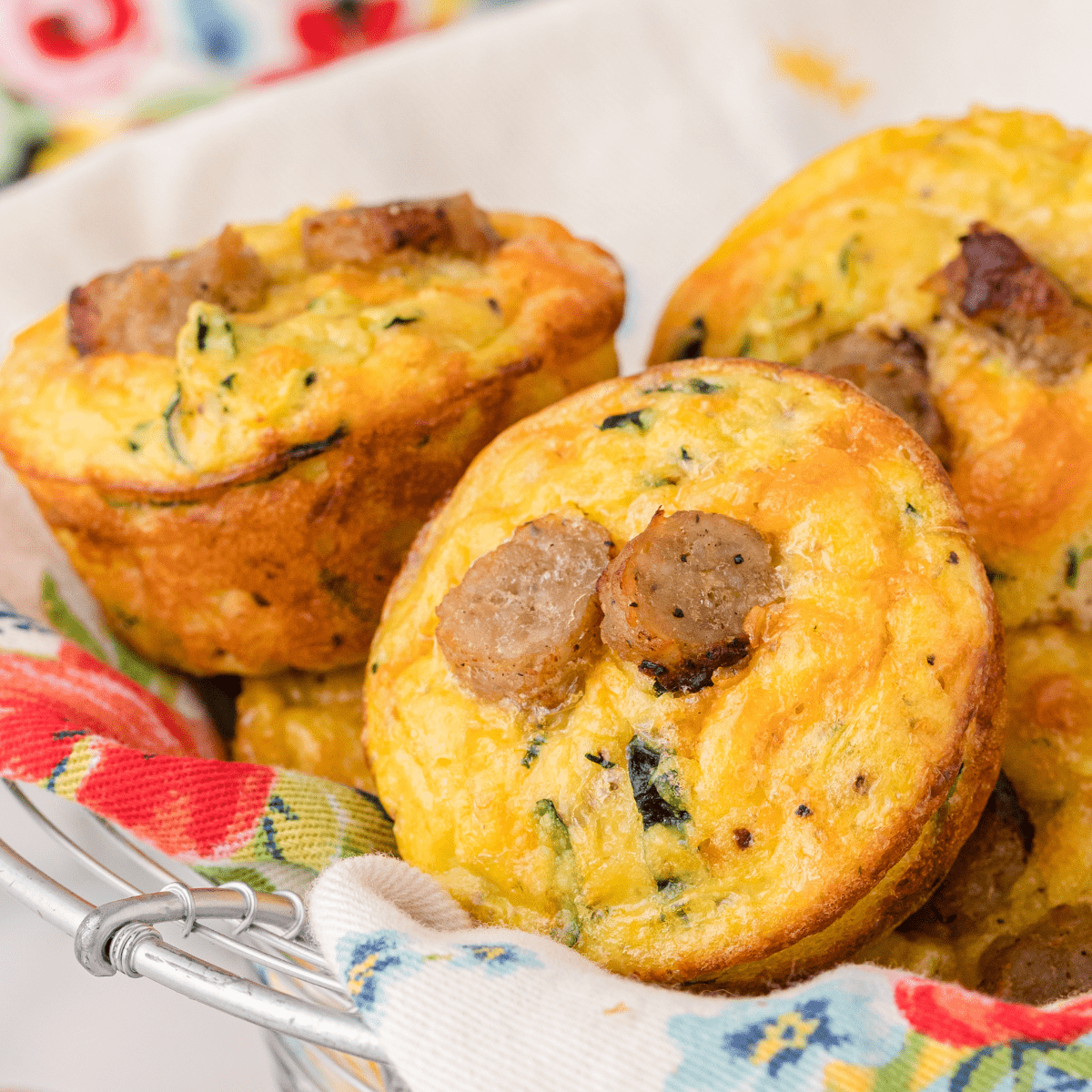 a basket full of sausage egg muffins with zucchini