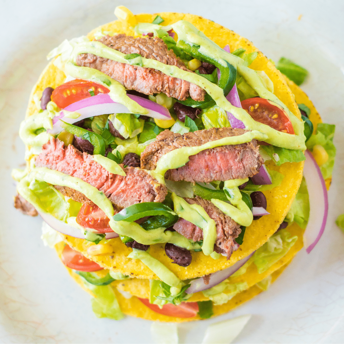 Steak tostada salad on a white plate