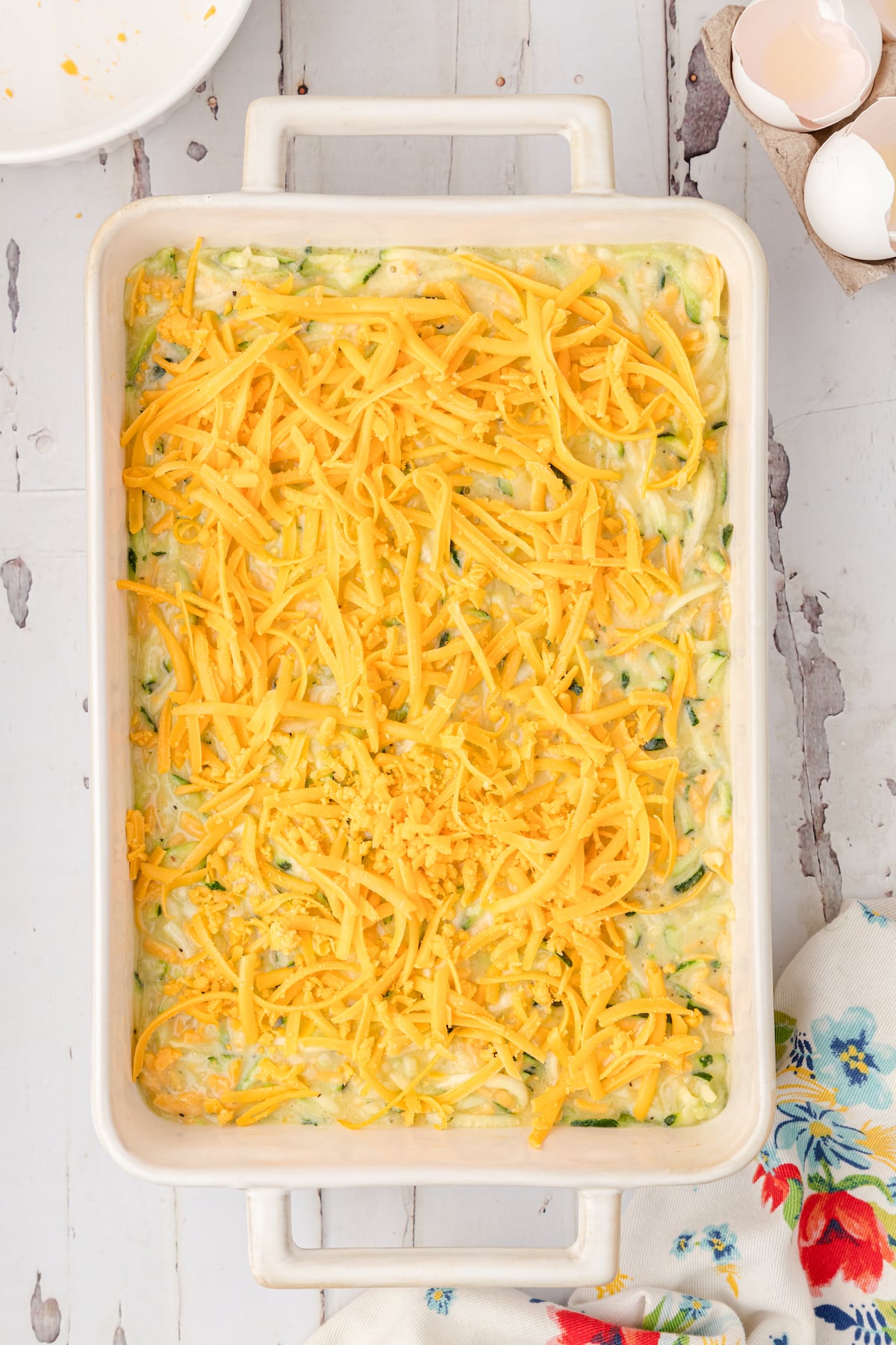 top zucchini batter with shredded cheddar cheese