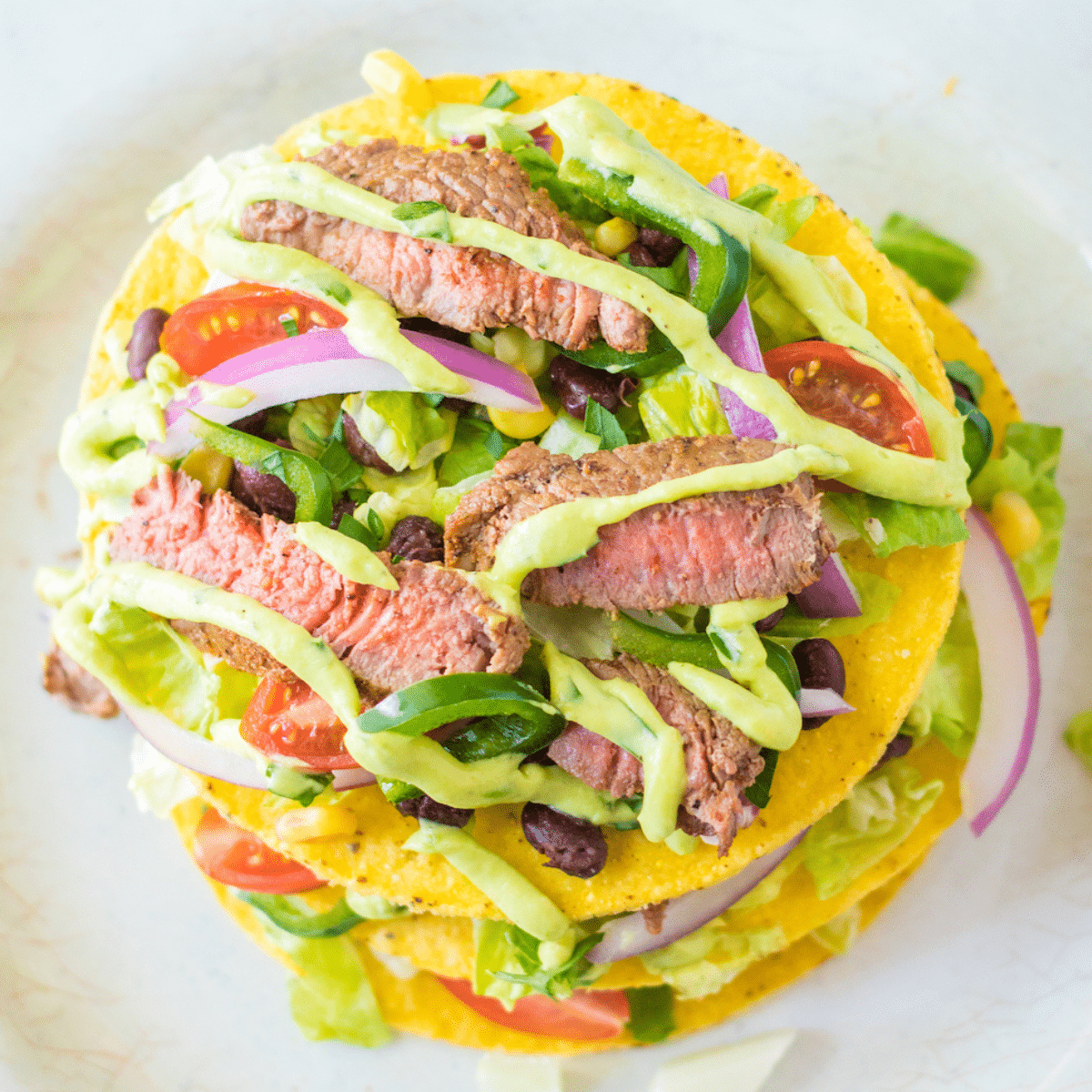 cilantro avocado lime salad drizzled on top of a tostada