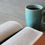 an open Bible with a mug of coffee