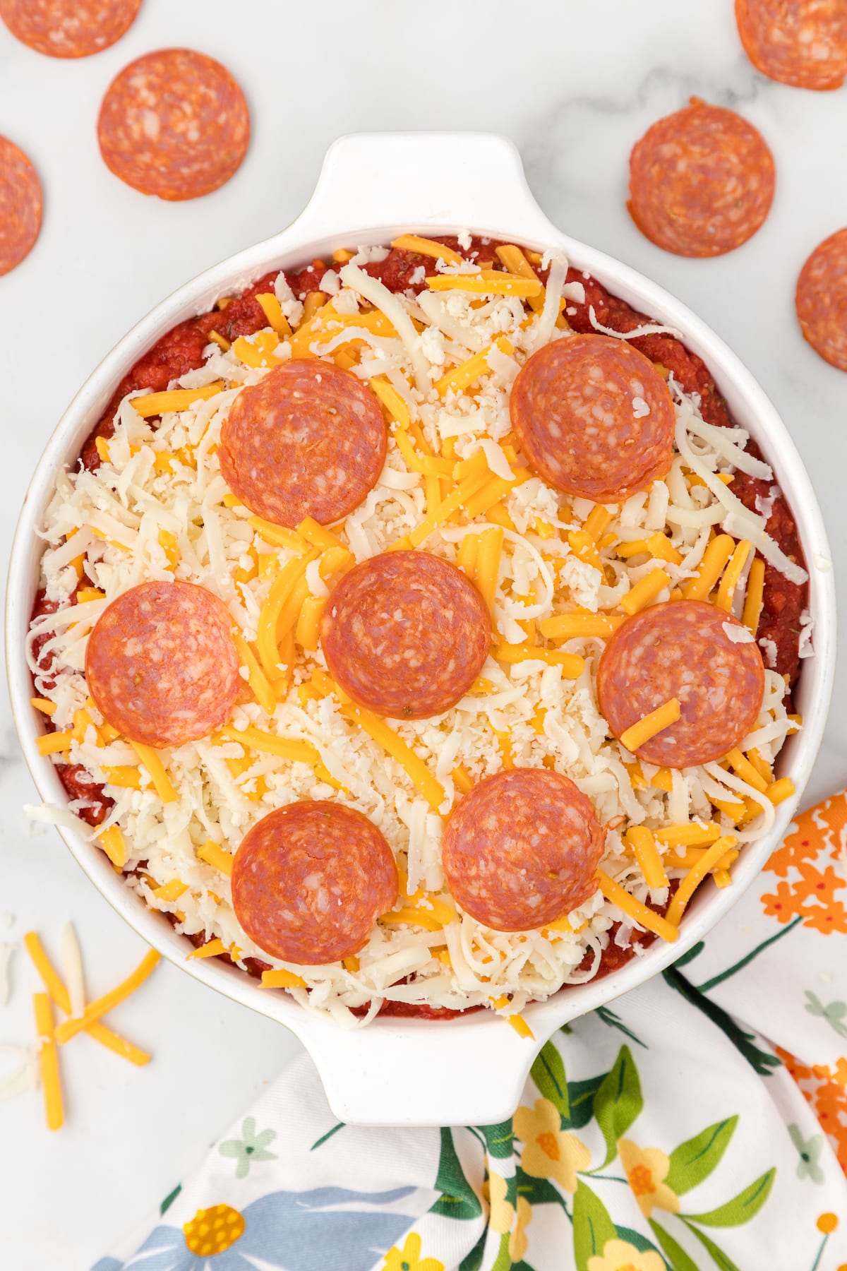 Top the pizza sauce with additional shredded cheese and pepperoni
