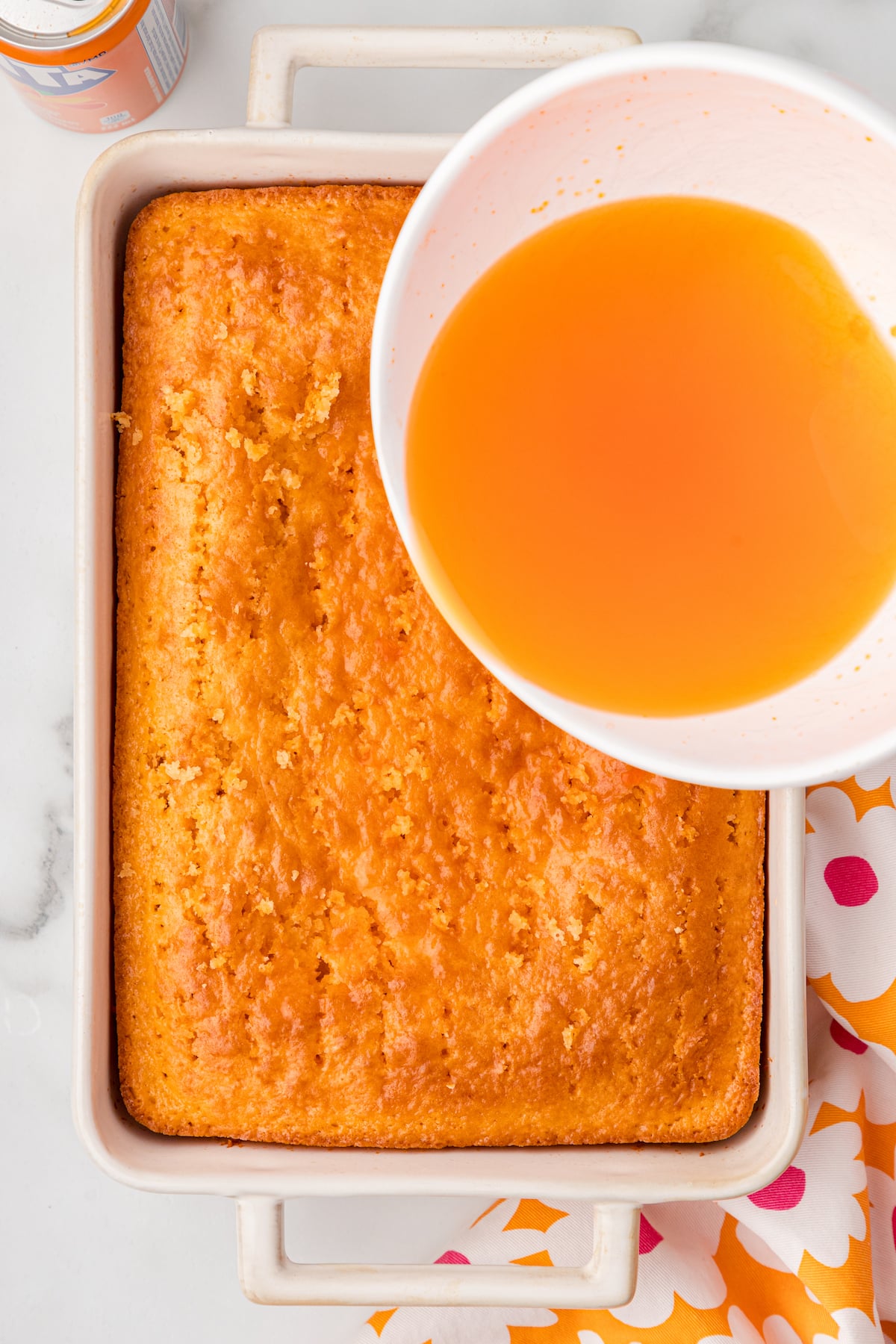 pour the orange jello over the cake that has been poked full of holes