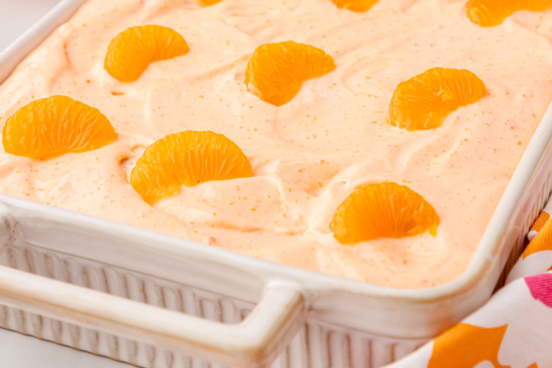 Orange Creamsicle Cake with orange frosting and mandarin oranges