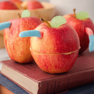 wormy apple snacks on top of a stack of books