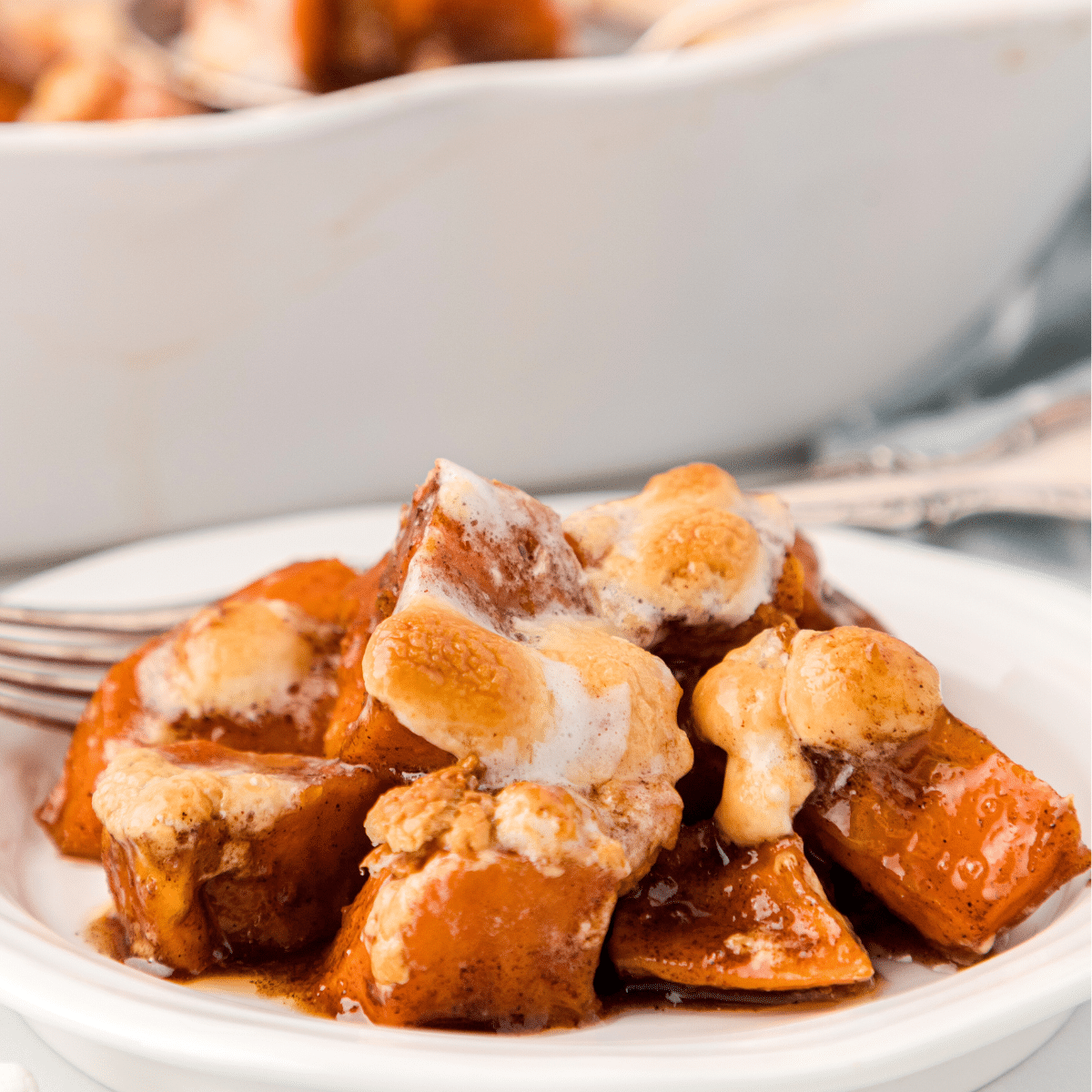 candied yams with marshmallows on a white plate
