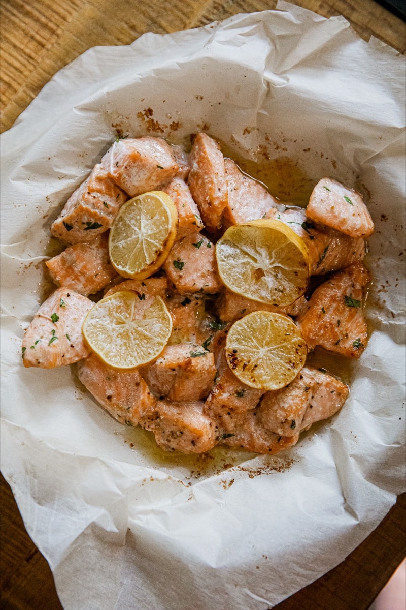 air fryer salmon bites topped with lemon slices and butter