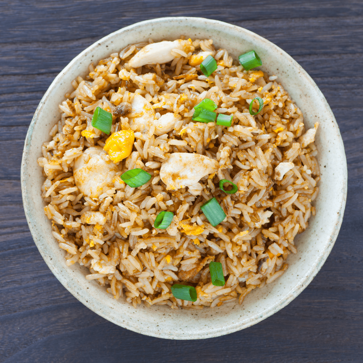 fried rice in a white bowl on a black table