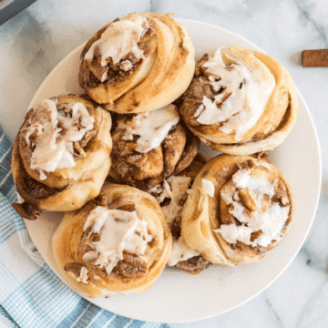 a plate of mini cinnamon rolls with vanilla frosting