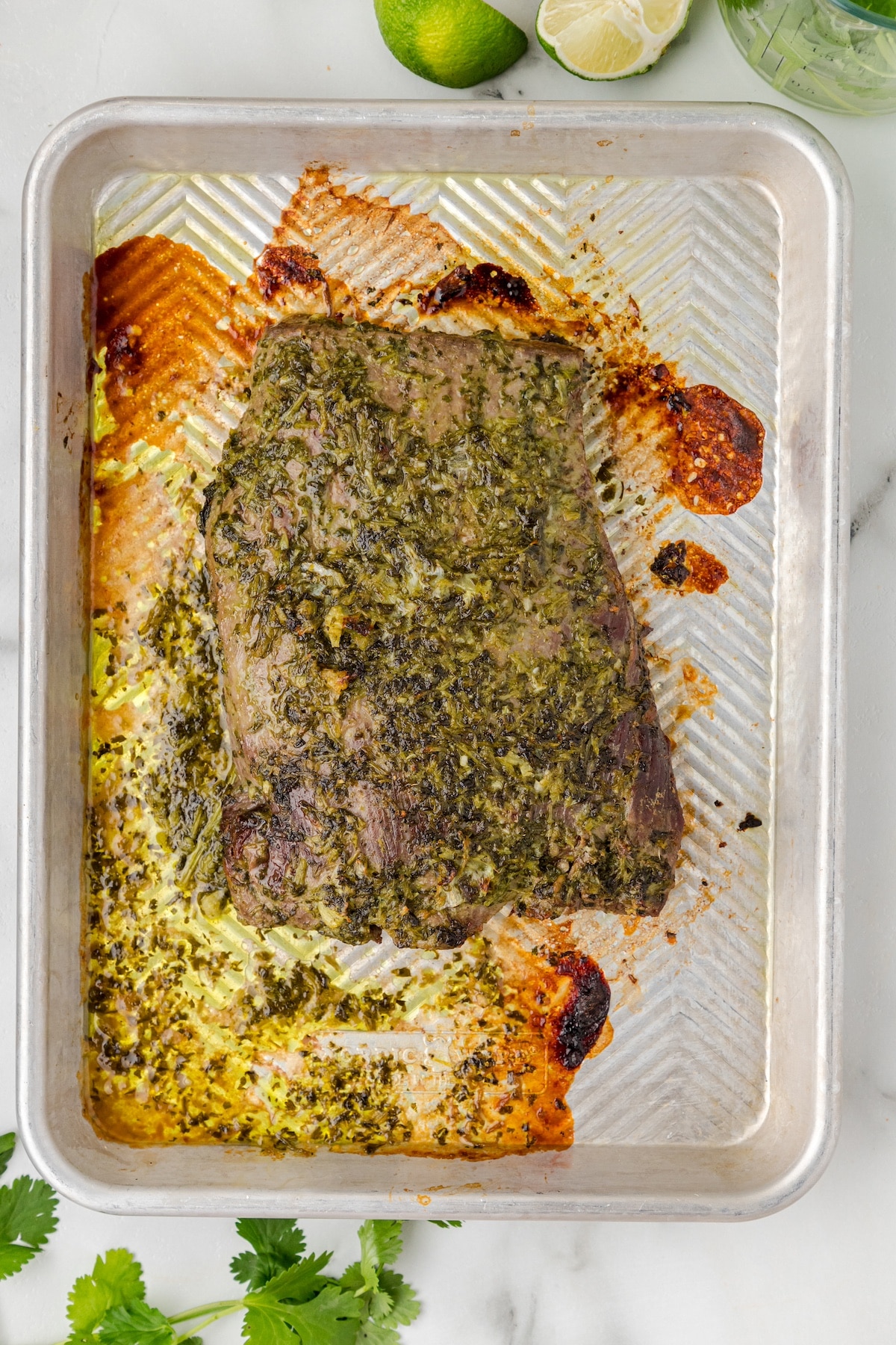 a cooked marinated flank steak on a baking sheet