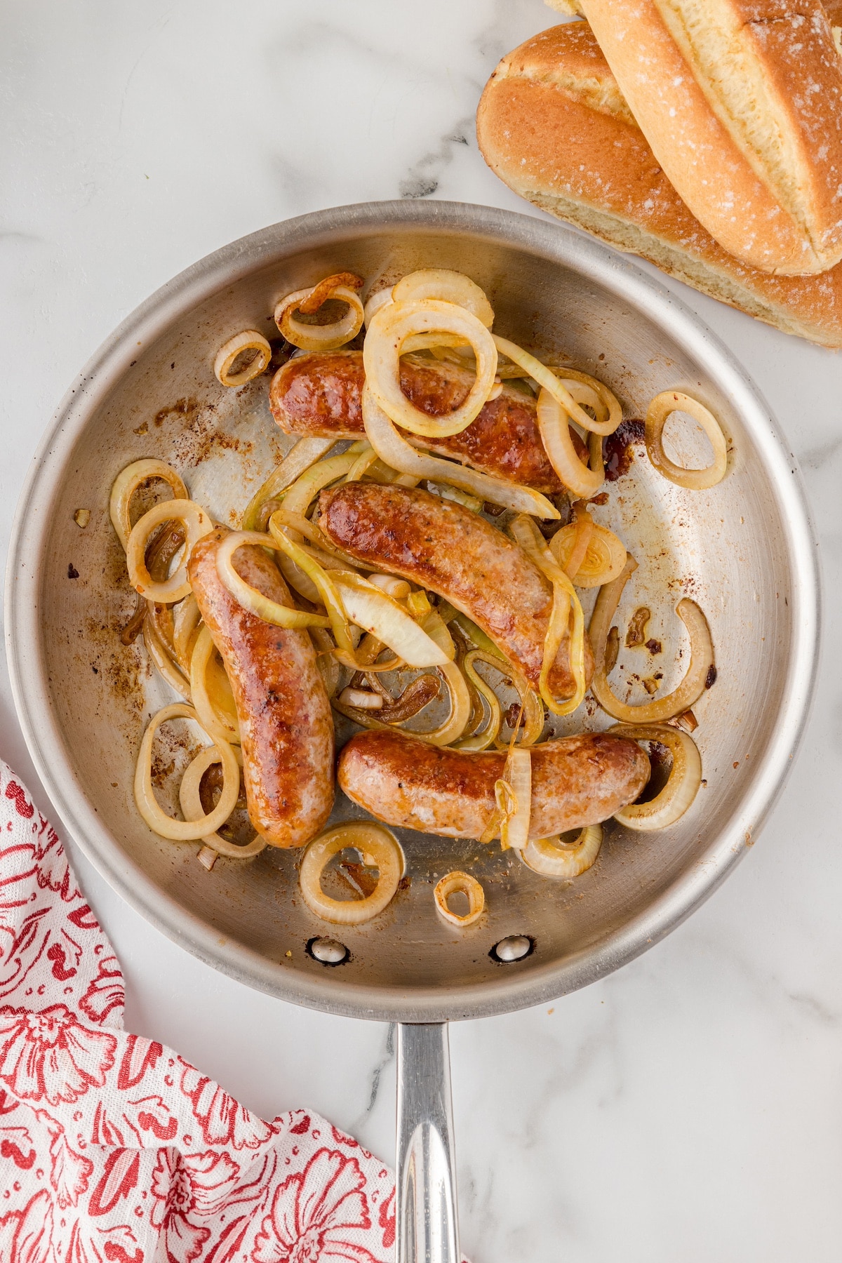 cooked onions and sausages in a skillet