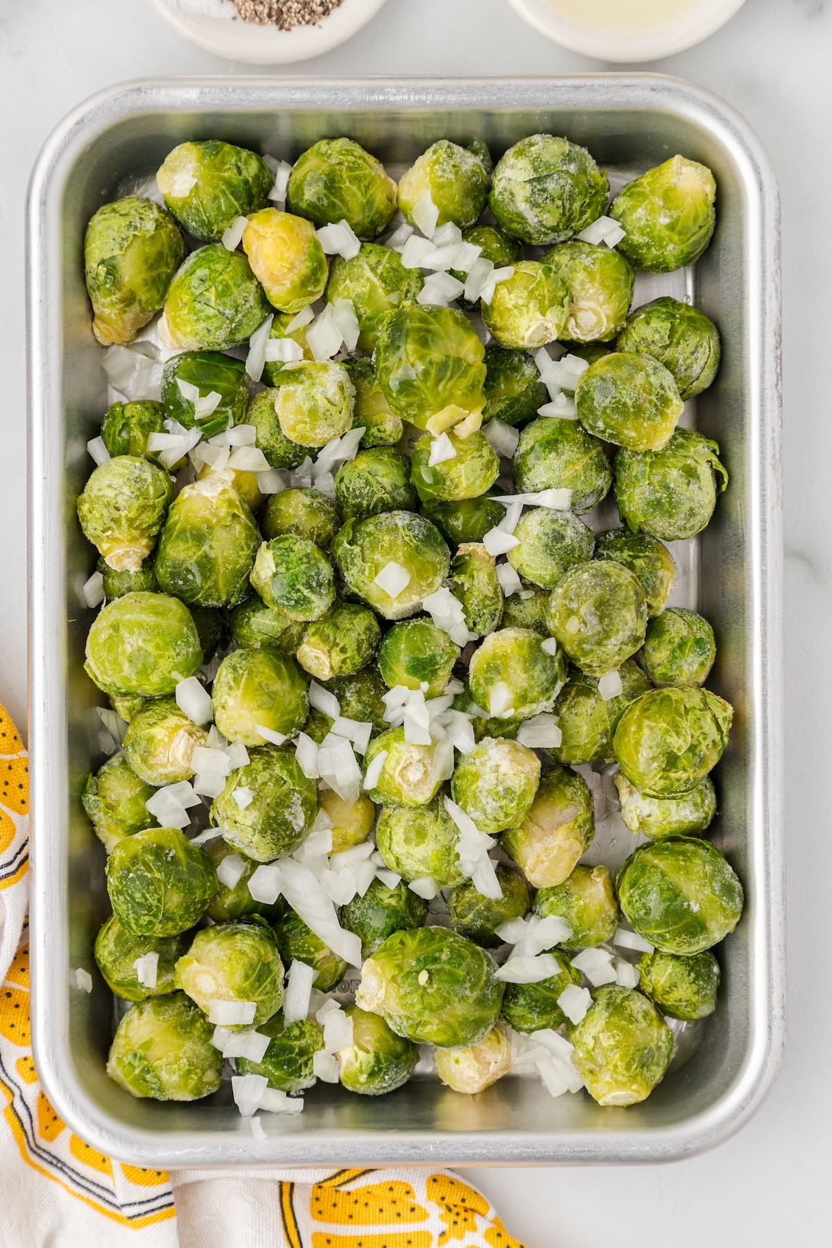 place the frozen brussels sprouts on a sheet pan with chopped onion