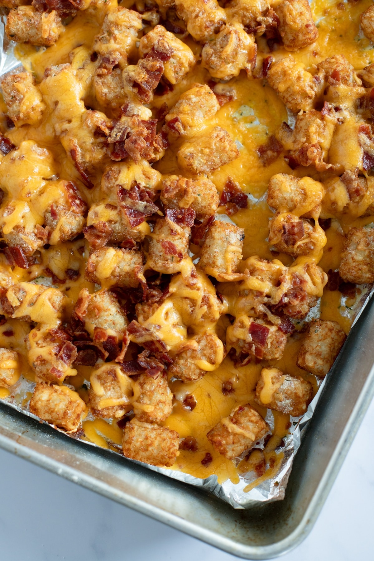 loaded tater tots topped with melted cheddar cheese and crumbled bacon