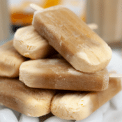 a stack of homemade root beer float popsicles on top of ice cubes