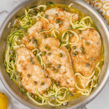 healthy chicken piccata with zucchini noodles in a skillet
