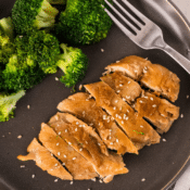 Instant Pot garlic chicken on a black plate with broccoli with a fork